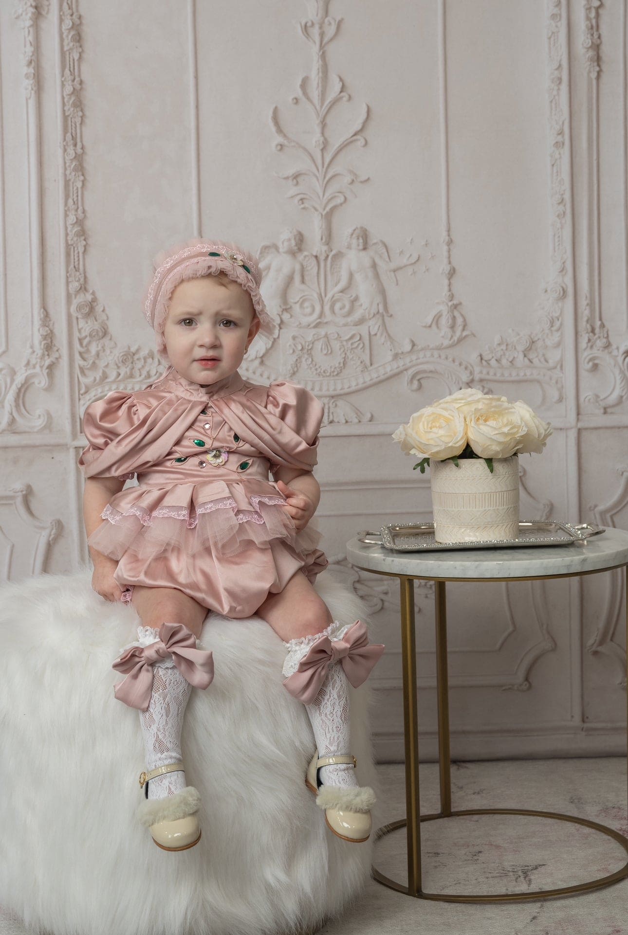 Baby girl in pink ruffle romper with puff sleeves and matching headband