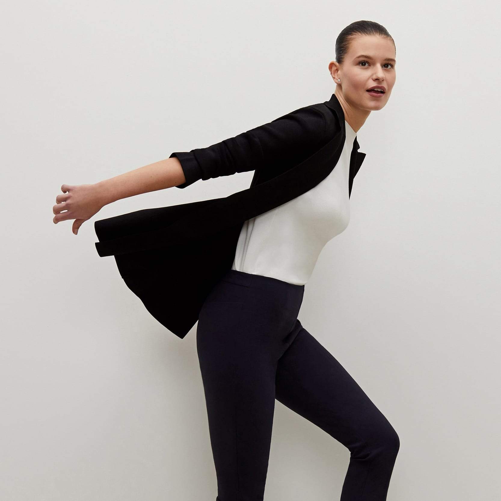 Side image of a woman standing wearing the foster pant in dark navy | Exclude
