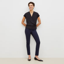 Front image of a woman standing wearing the foster pant in dark navy