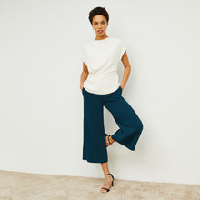 Front image of a woman standing wearing the Nejvi Top in alabaster