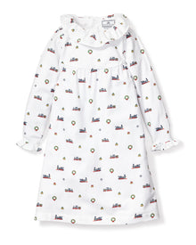 The Girls Twill Scarlett Nightgown in Arctic Express by Petite Plume offers cozy-soft white twill with a ruffled collar and cuffs, adorned with festive prints of trains, wreaths, and snowflakes, perfect holiday sleepwear.