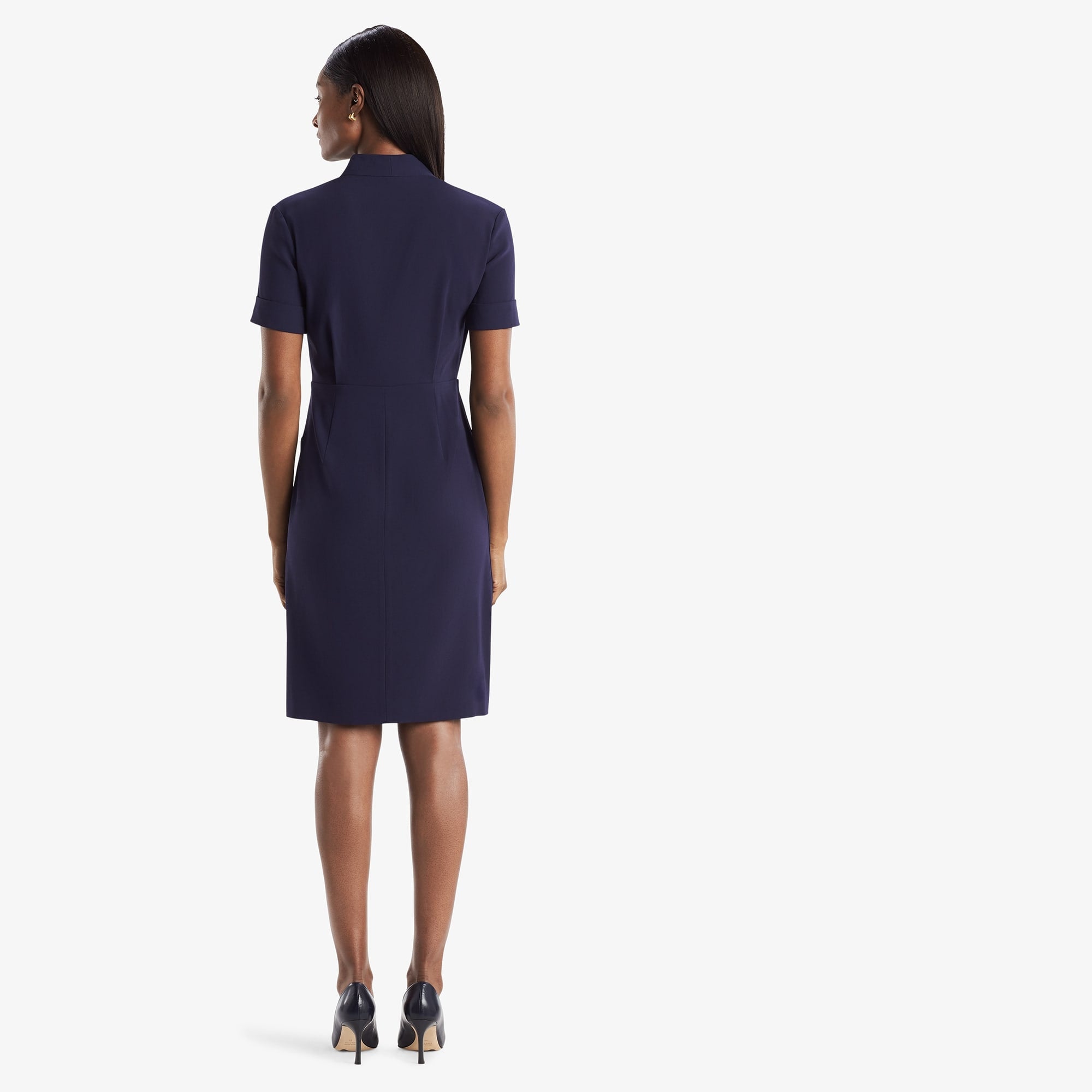 Back image of a woman standing wearing theTory Dress in dark iris