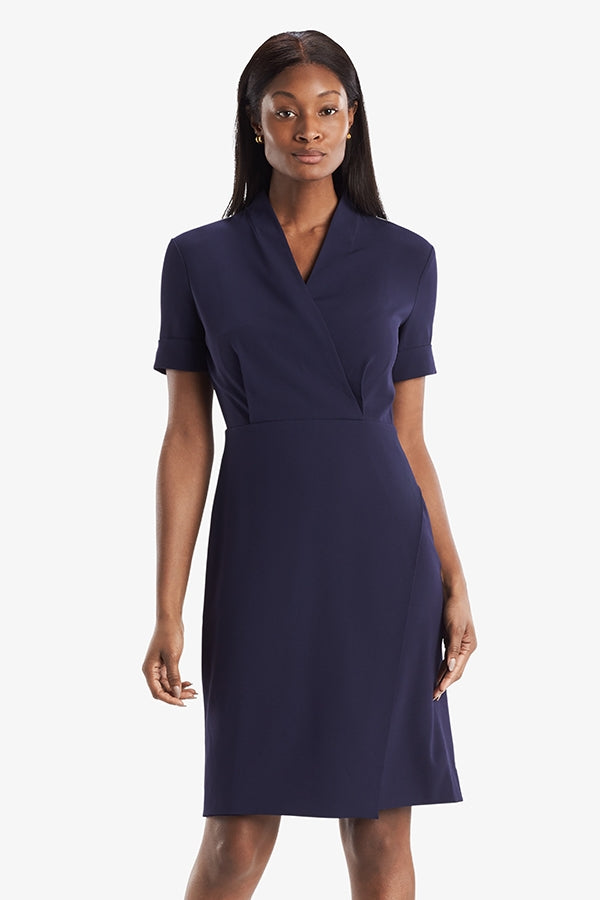 Front image of a woman standing wearing theTory Dress in dark iris | Grid | Exclude
