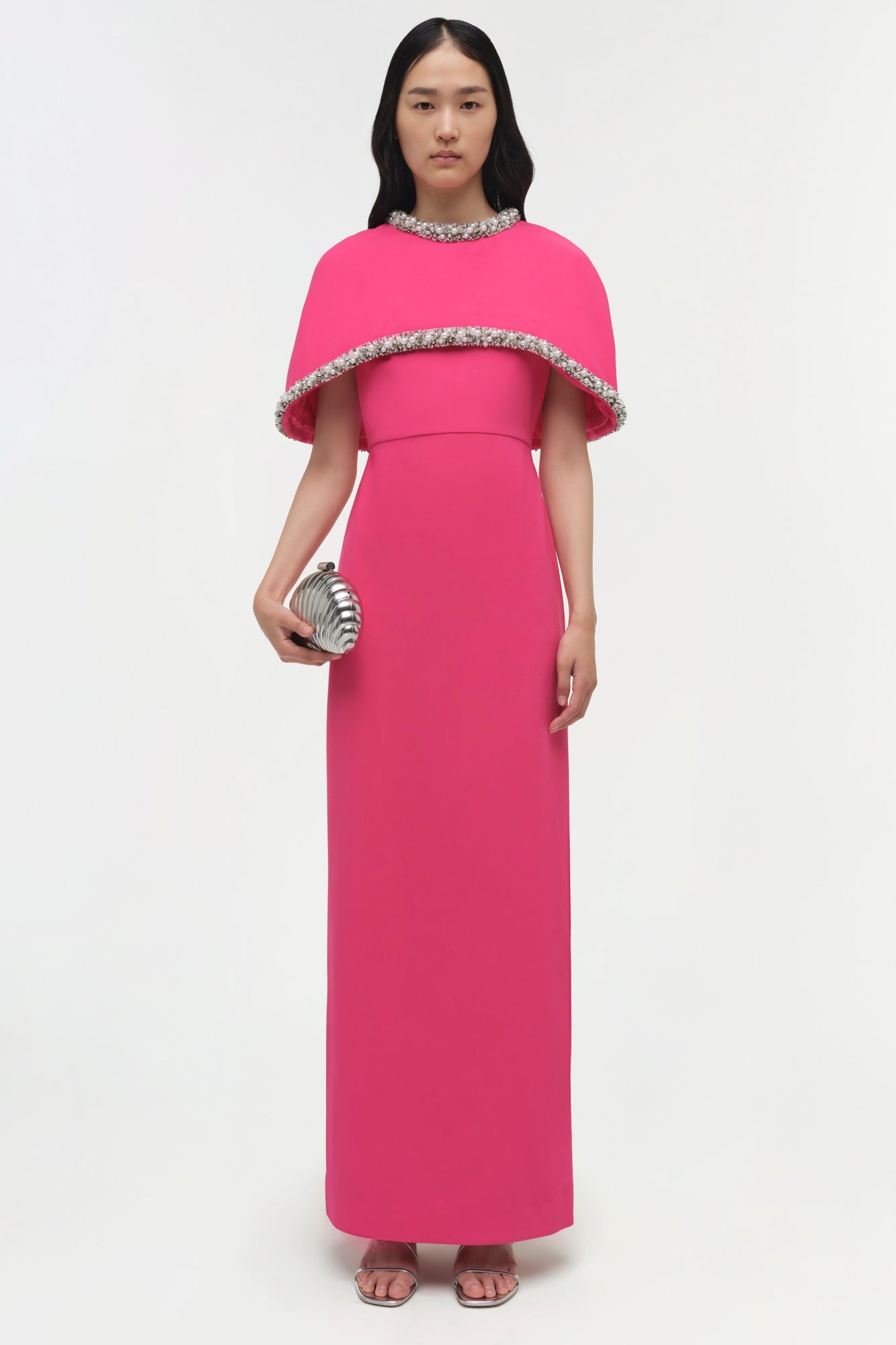 Hot pink floor-length gown with beaded cape overlay and embellished neckline.