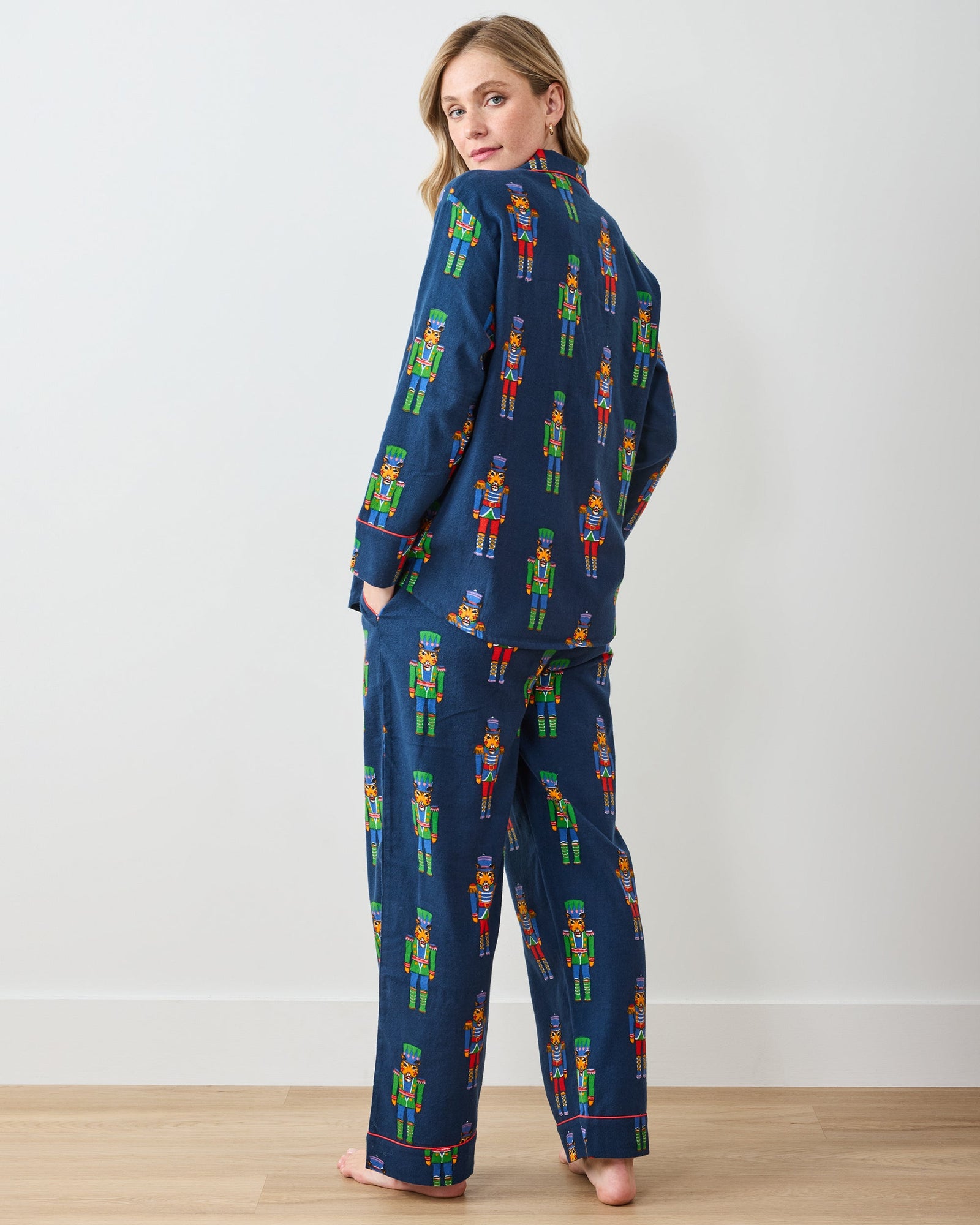 Back view of navy long pajama set with colorful leopard nutcracker print and red piping