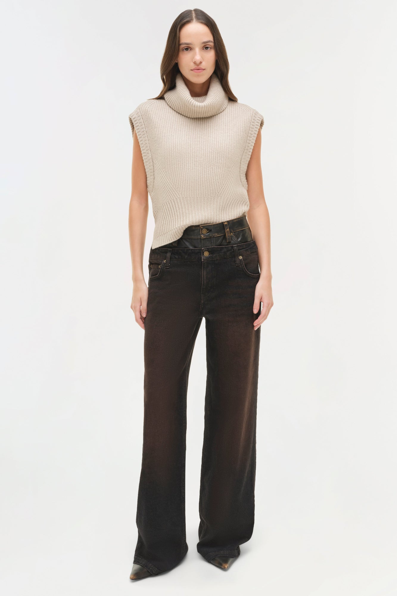 Black denim jeans with double waistband detail, styled with cream sleeveless turtleneck sweater.