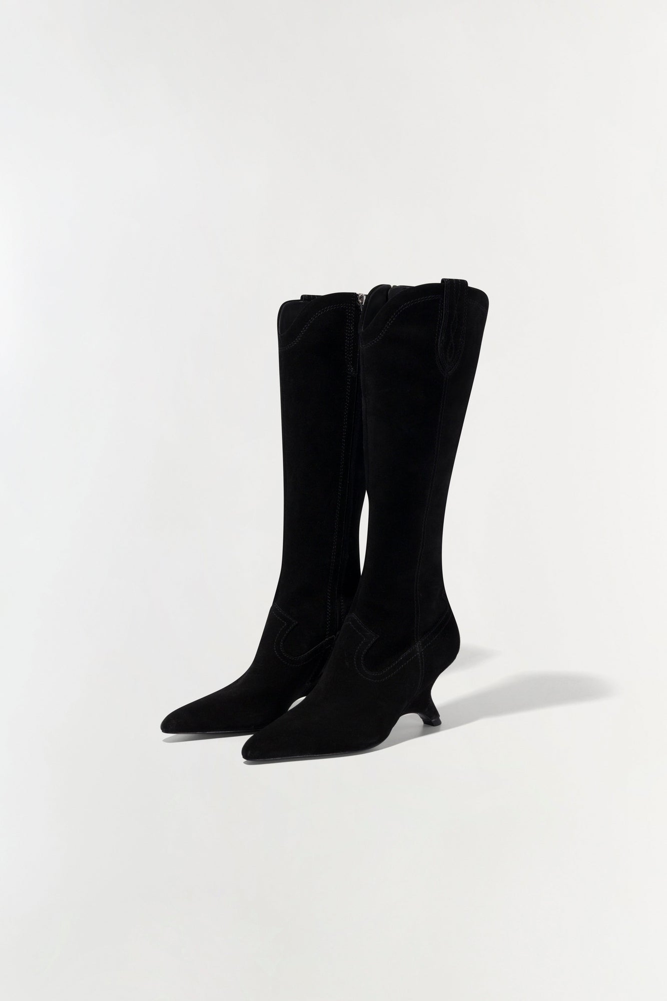 Black suede knee-high boots with pointed toes and kitten heels, shown from the front on a neutral background.