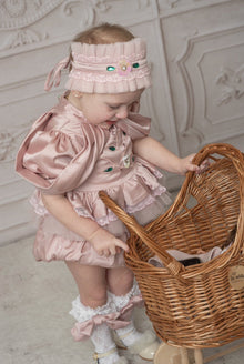 Baby girl in pink ruffle romper with matching headband