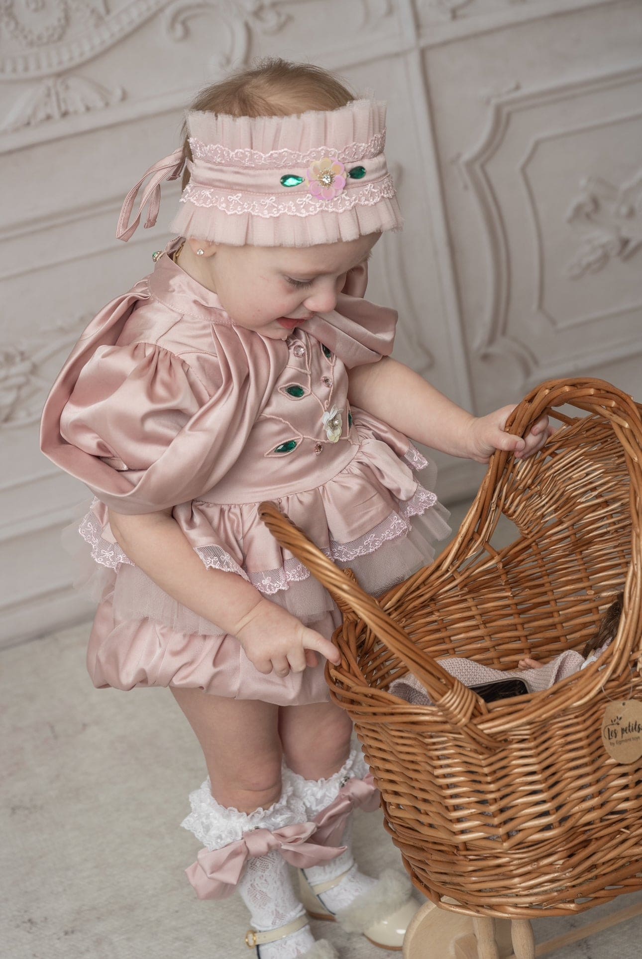 Baby girl in pink ruffle romper with matching headband