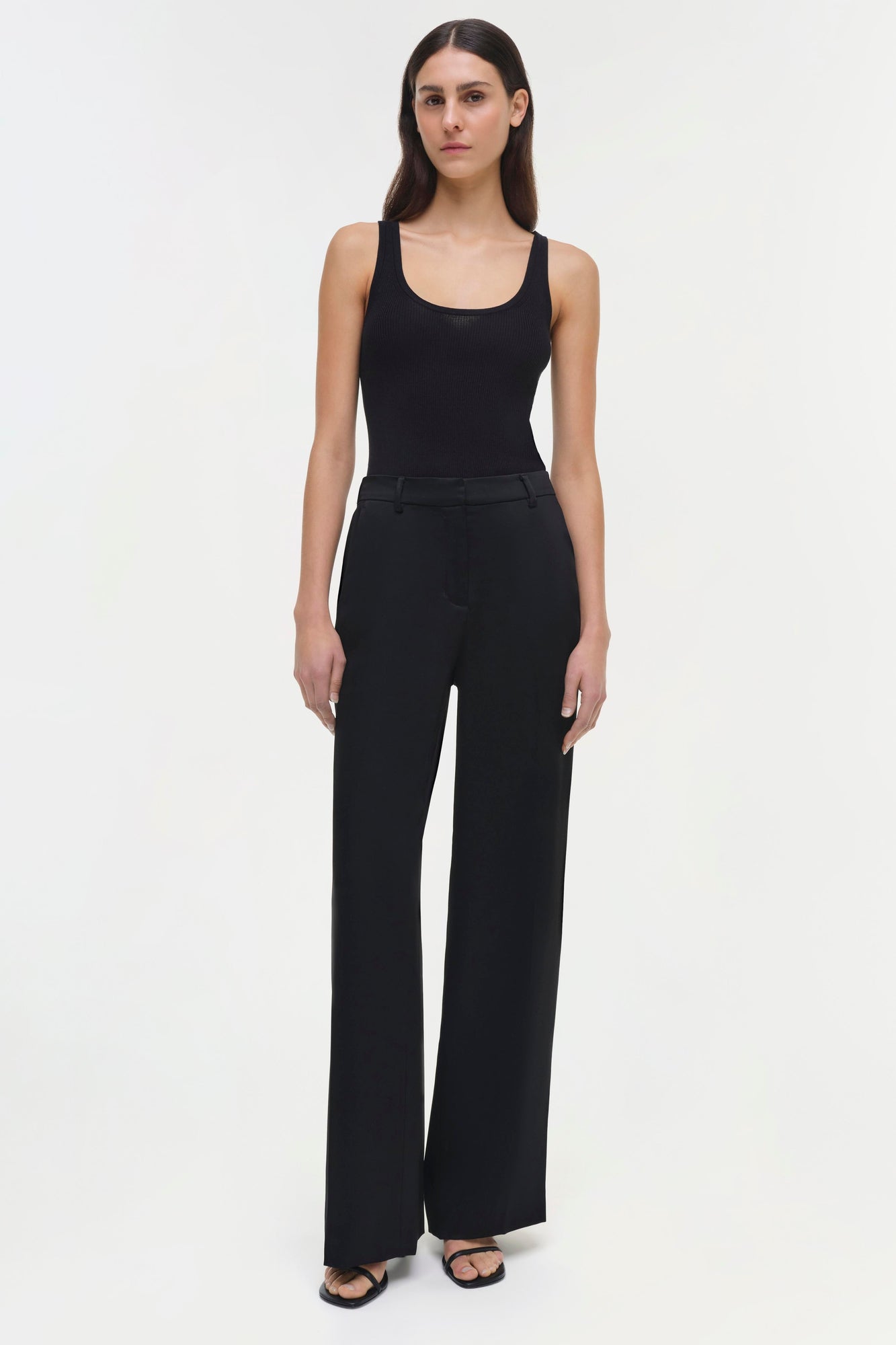 Woman wearing black ribbed tank top and black wide-leg pants with flat front styling.