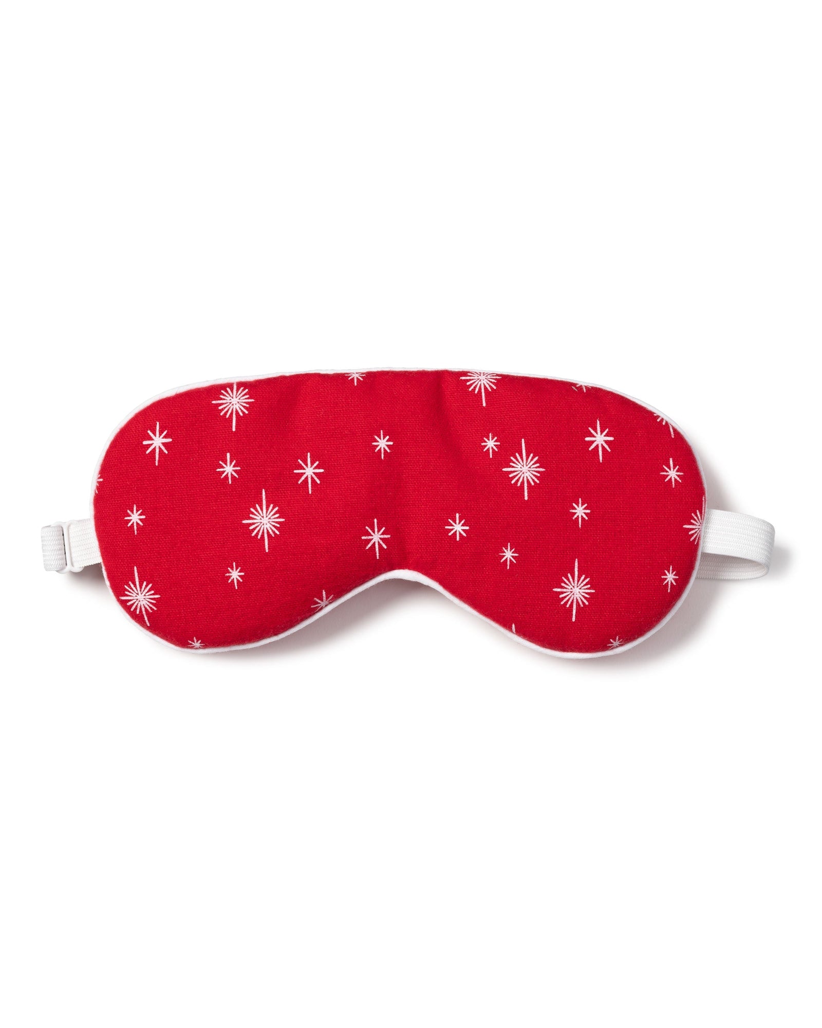 The Adults Flannel Sleep Mask in Starry Night by Petite Plume, featuring white stars on red and an adjustable strap, makes a perfect gift. Pair it with matching eye masks for added thoughtfulness.