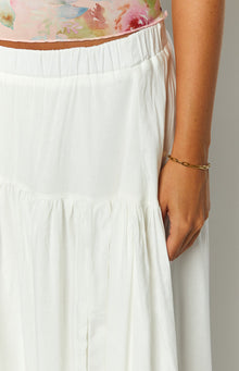 gold chain bracelet and white tiered maxi skirt on model 