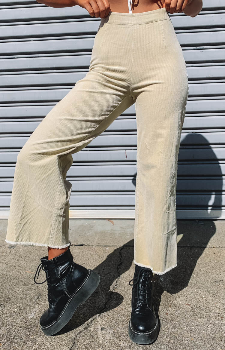 High-waisted beige corduroy wide-leg pants with a distinctive raw frayed hem