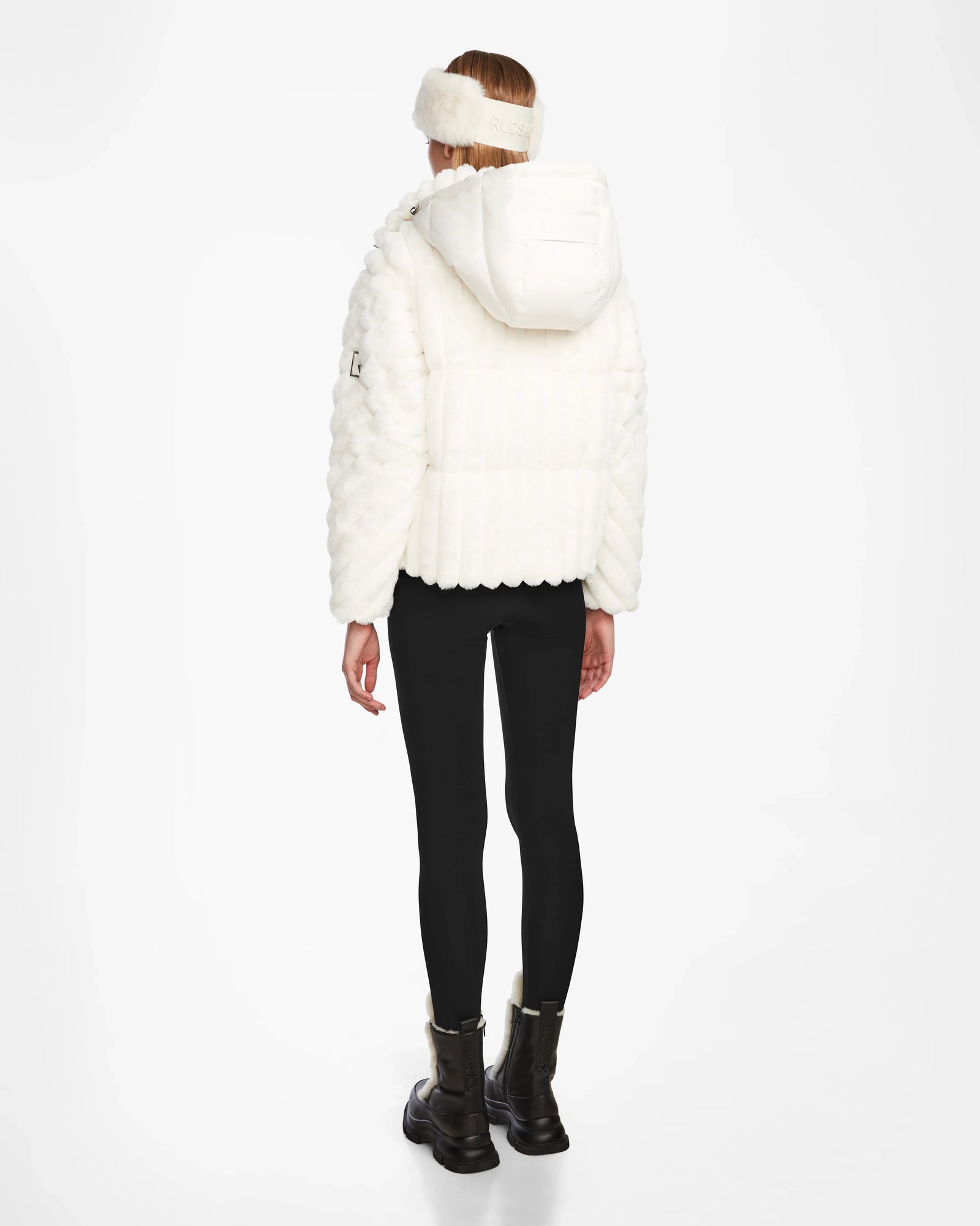 A woman wearing a white Rudsak ANASTASIA - 8124804 Iceland coat with RDS-certified down and black pants.
