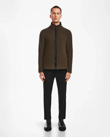 A person faces forward wearing the ARAGON - 6524539 Army fleece full-zip jacket by Rudsak, paired with black pants and shoes, set against a plain white background.
