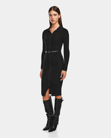 A woman poses against a white background wearing the CARLI - 8524573 Black dress by Rudsak— a fitted, long-sleeve black knit button-down with a collar and slim vegan leather belt—paired with knee-high black boots.