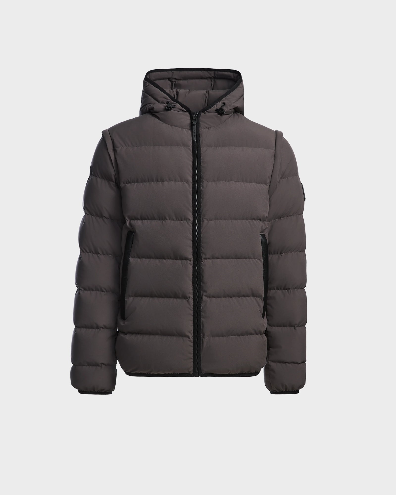 The Rudsak DEMIAN M-R - M123504 Grey is a dark gray men’s down puffer jacket with a hood, front zip closure, and side pockets, made from sustainable recycled fabric. Shown on a plain white background.