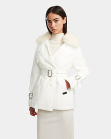 A woman models the Rudsak ELENOR - 8124707 Iceland white trench coat with a shearling collar over a white turtleneck and long skirt, standing against a plain light background.