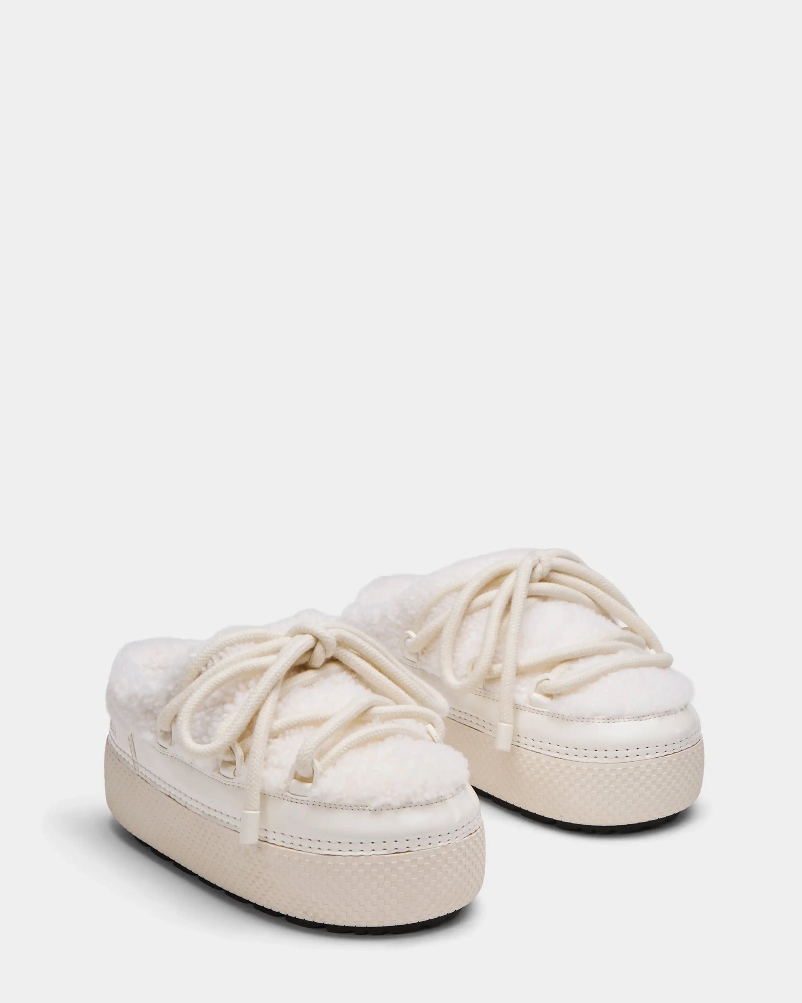 The Rudsak HARRIET - 8224519 Iceland slippers are off-white womens slip-ons with thick rubber soles, soft faux shearling lining, and decorative laces, styled like cozy fur-lined boat shoes.