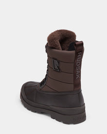 The REAGAN - 6224501 Espresso by Rudsak is a brown mens winter boot with a fur-lined interior, lace-up front, and RUDSAK branding on the heel and pull tab, shown against a plain white background.