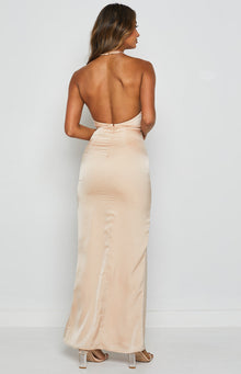 Back view of a champagne satin formal dress with a halter neck strap, low scoop back, exposed zipper, and ruched detail
