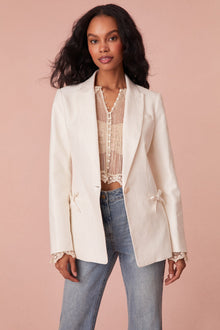 Tailored jacket with a slightly oversized fit, a longer silhouette, single button closure, and two pockets at the hip area.