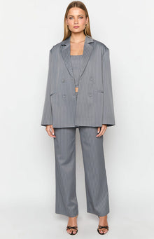 Front view of a grey pinstriped oversized blazer worn open over a matching crop top and wide-leg pants