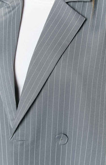 Close-up of the grey pinstriped blazer showing a notched lapel, button, and buttonhole