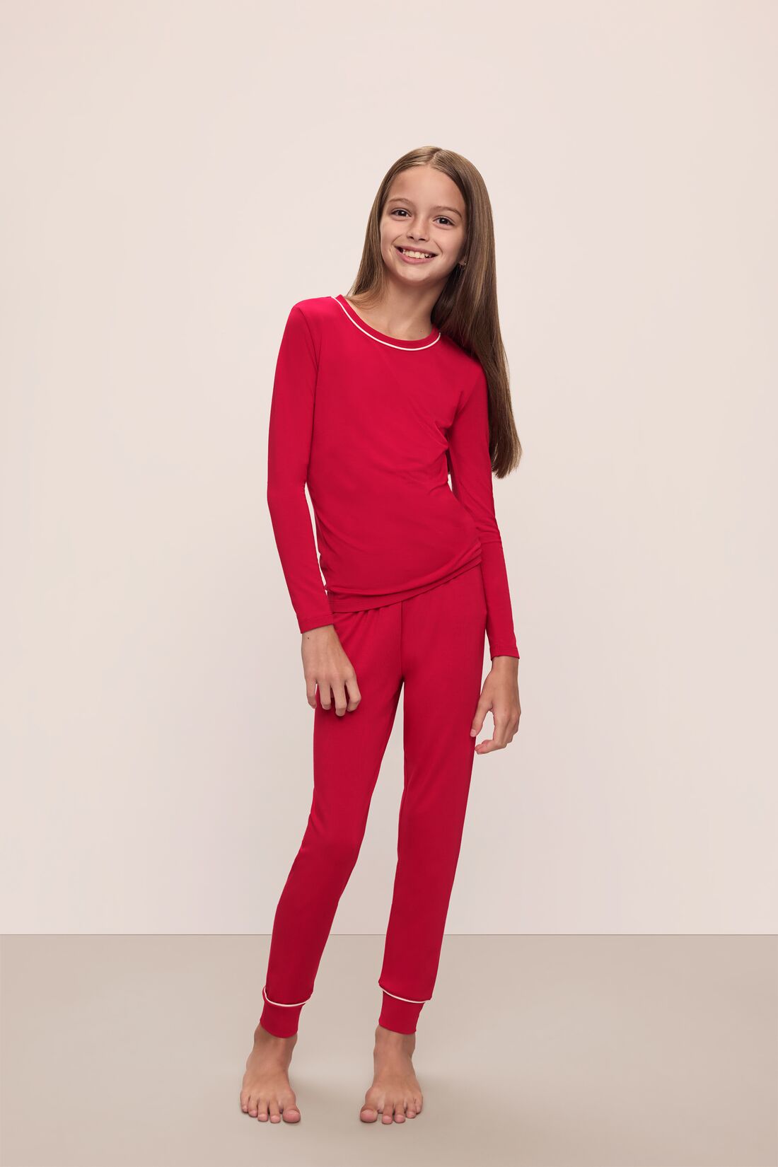 Model wears Kids TENCEL Modal Unisex Long PJ Set in Haute Red/Ivory.