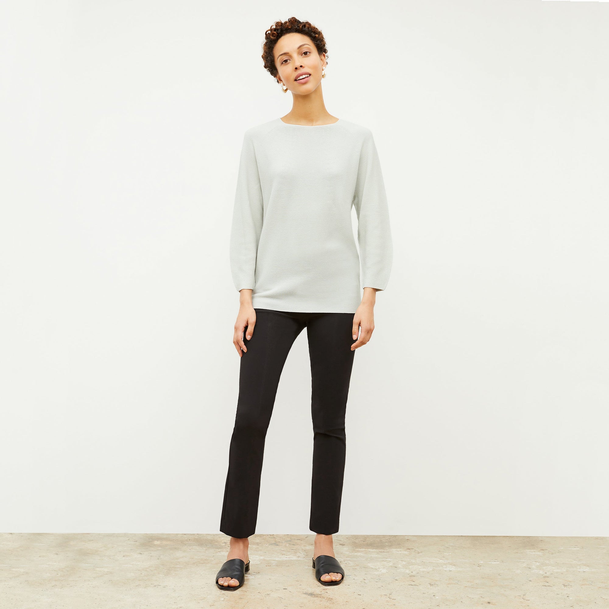 Front image of a woman standing wearing the Foster Pant—Everstretch in Black | Exclude