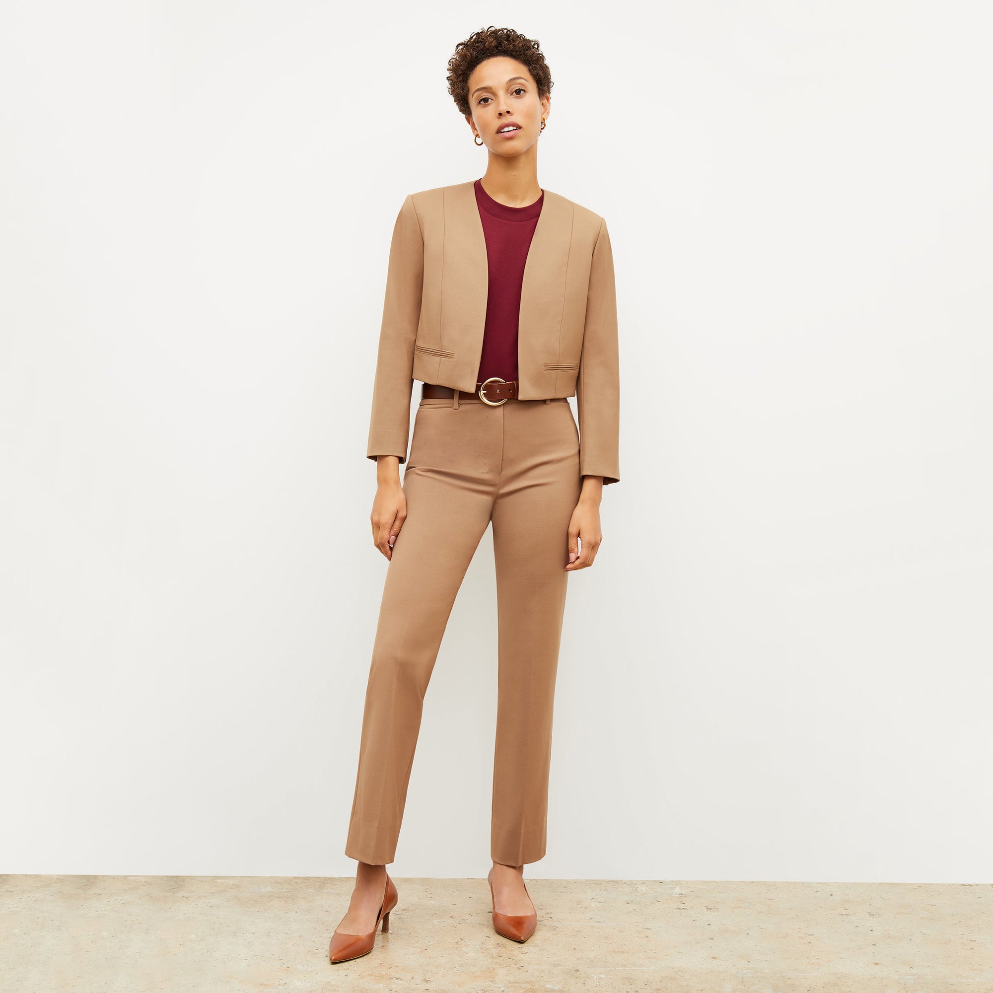 Front image of a woman standing wearing the Neale jacket in camel