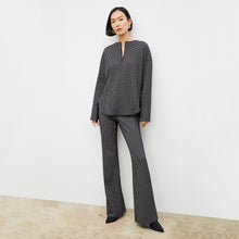 Front image of a woman wearing the horton pant in black and white houndstooth