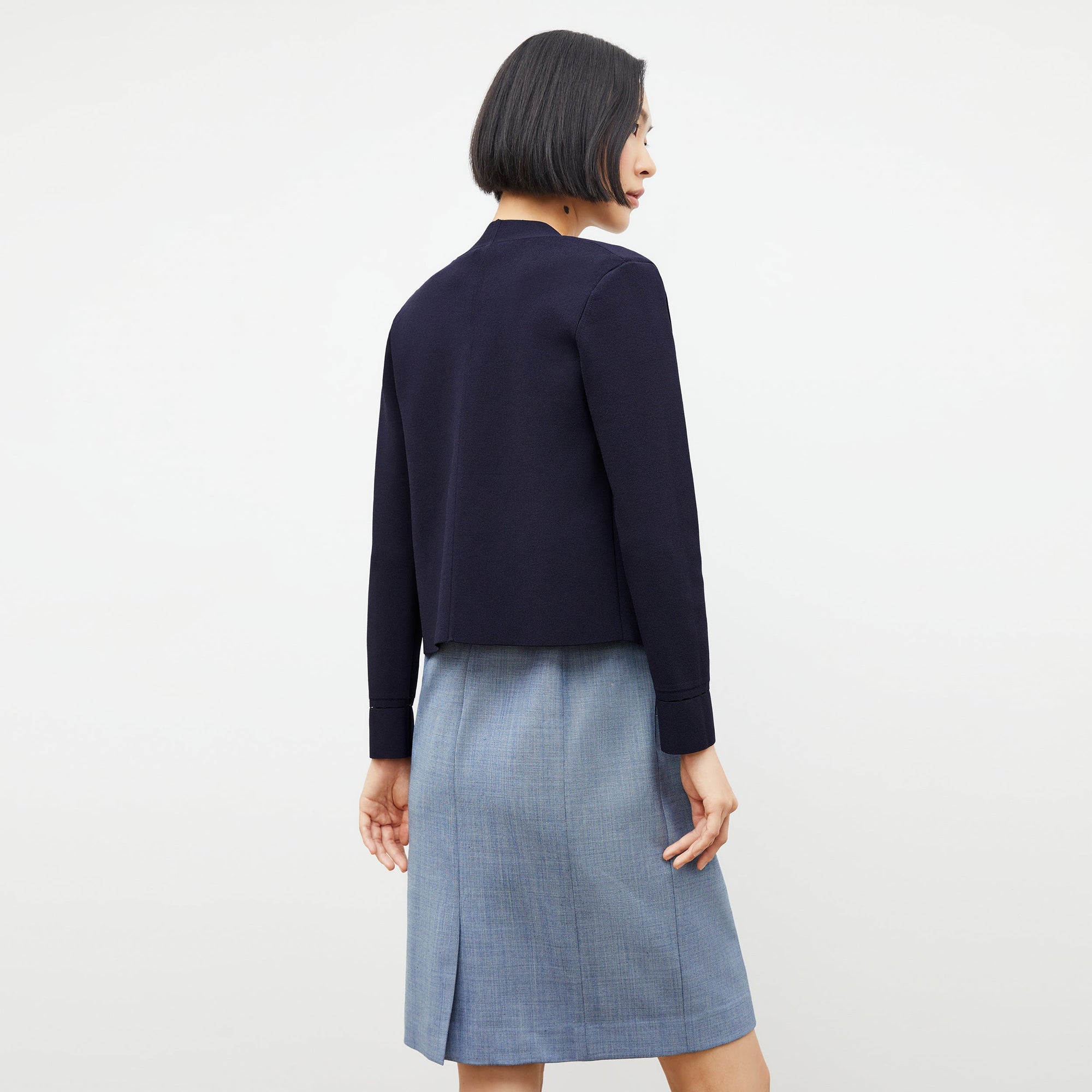 back image of a woman wearing the sant ambroeus jardigan in navy