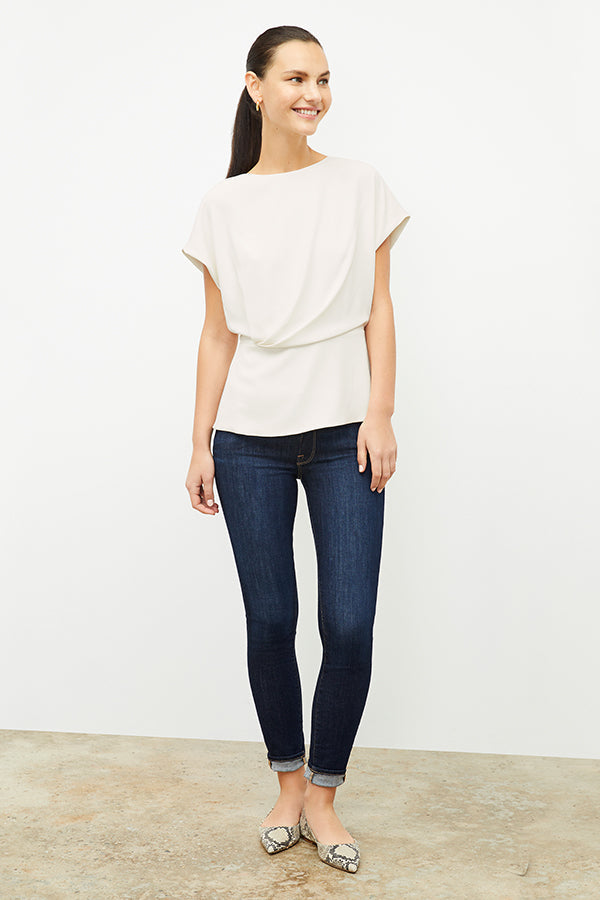 Front image of a woman standing wearing the Nejvi Top in alabaster | Exclude | Grid Hover