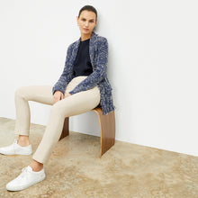 Front image of a woman sitting wearing the foster pant in bone