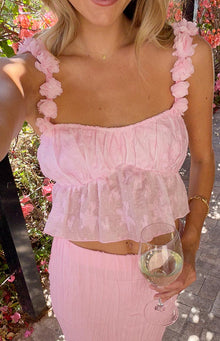 Close-up of the pink top showing the shoulder strap with layered 3D flowers and gathered textured dot fabric