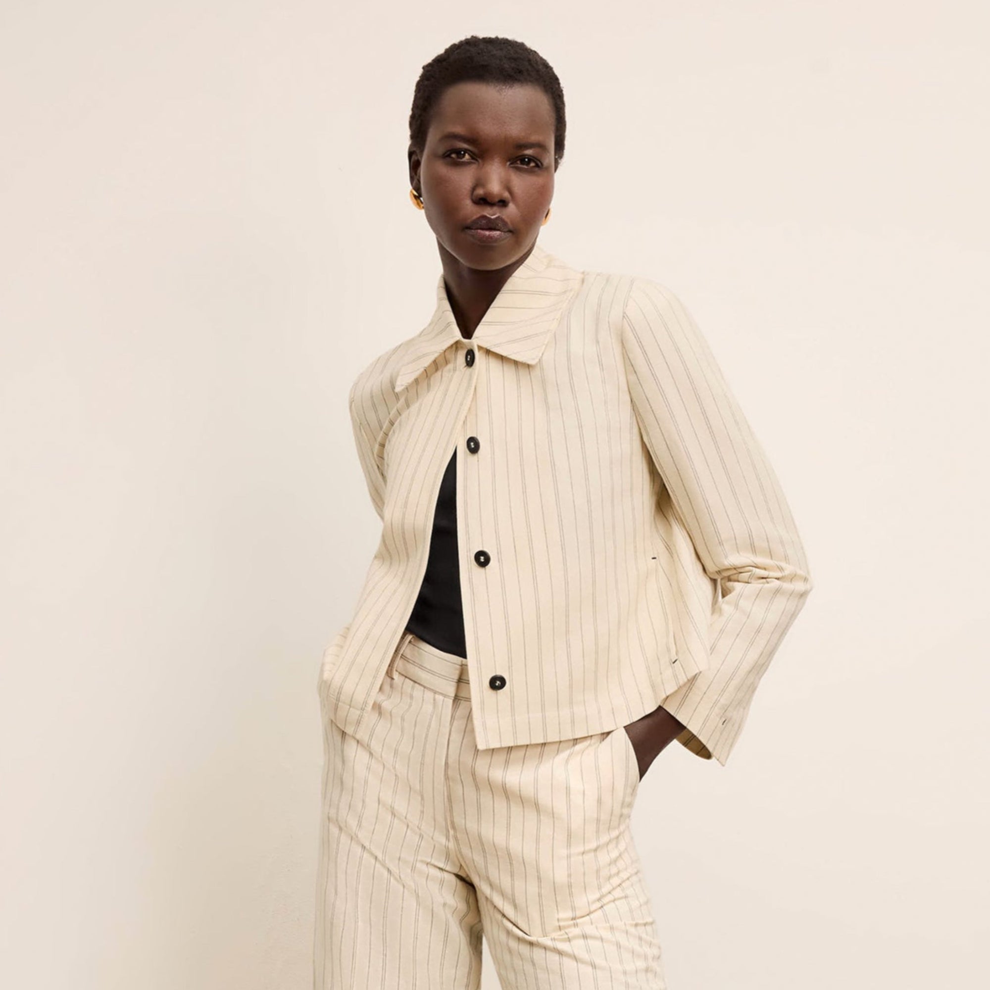 front image of a woman wearing the nicky jacket in linen stripe