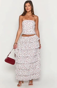Rear view of a white floral ruffle maxi skirt with tiered ruffles and a small floral print