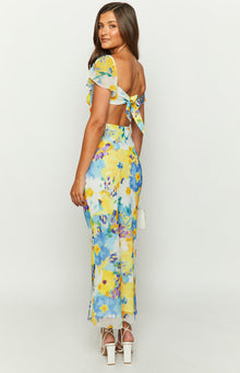 Rear-side view of a blue and yellow floral chiffon maxi dress with a tie-back detail and waist cutouts