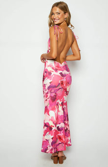 Rear view of a pink print maxi dress with tie-up spaghetti straps, a white upper back panel, low scoop back, and ruched waist
