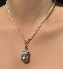 Super Moon Opals with Silvery Baroque Pearl Charm hanging from the neck.