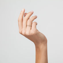 Model. A close-up shot of a hand wearing a diamond eternity ring.