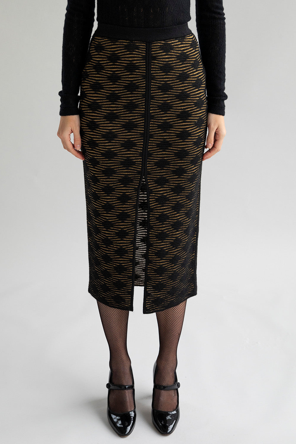 Slim-fitting golden black pencil skirt with a subtle pattern and front slit, styled to show a smooth, streamlined look when worn as intended.