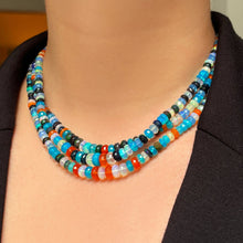 A model wears a blazer and a triple strand of Jaipur Jazz faceted opal necklaces around her neck.