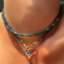 Night sky faceted opal necklace with a small sapphire charm lock with molten knot charm with star sapphire worn layered on the neck.