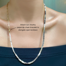 Shimmering beaded necklace made of faceted opals in shades of black, green, and blue on a gold linking ovals clasp. 