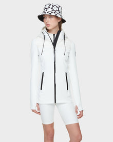 A woman wearing the CAMIRA - 8122011 WHITE jacket and shorts by Rudsak, ideal for outdoor workouts.