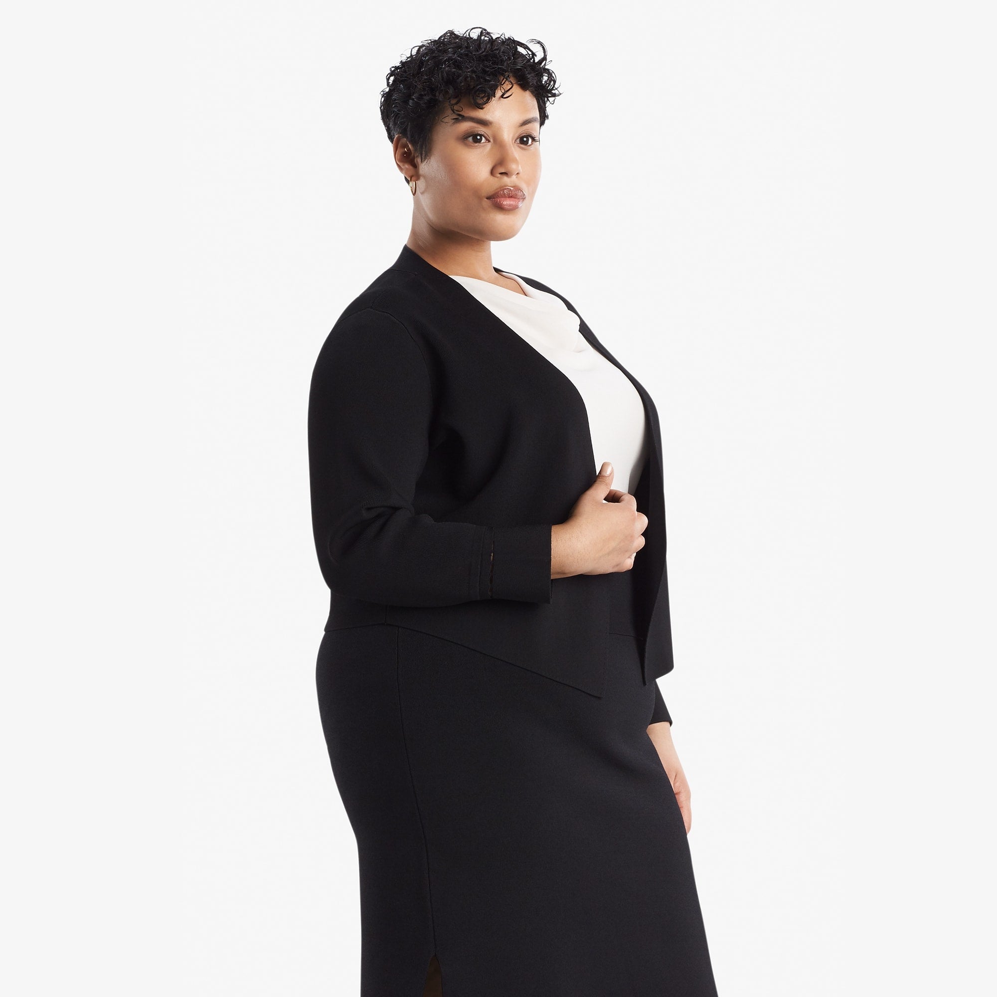 Side image of a woman standing wearing the Sant Ambroeus jardigan in black | Exclude