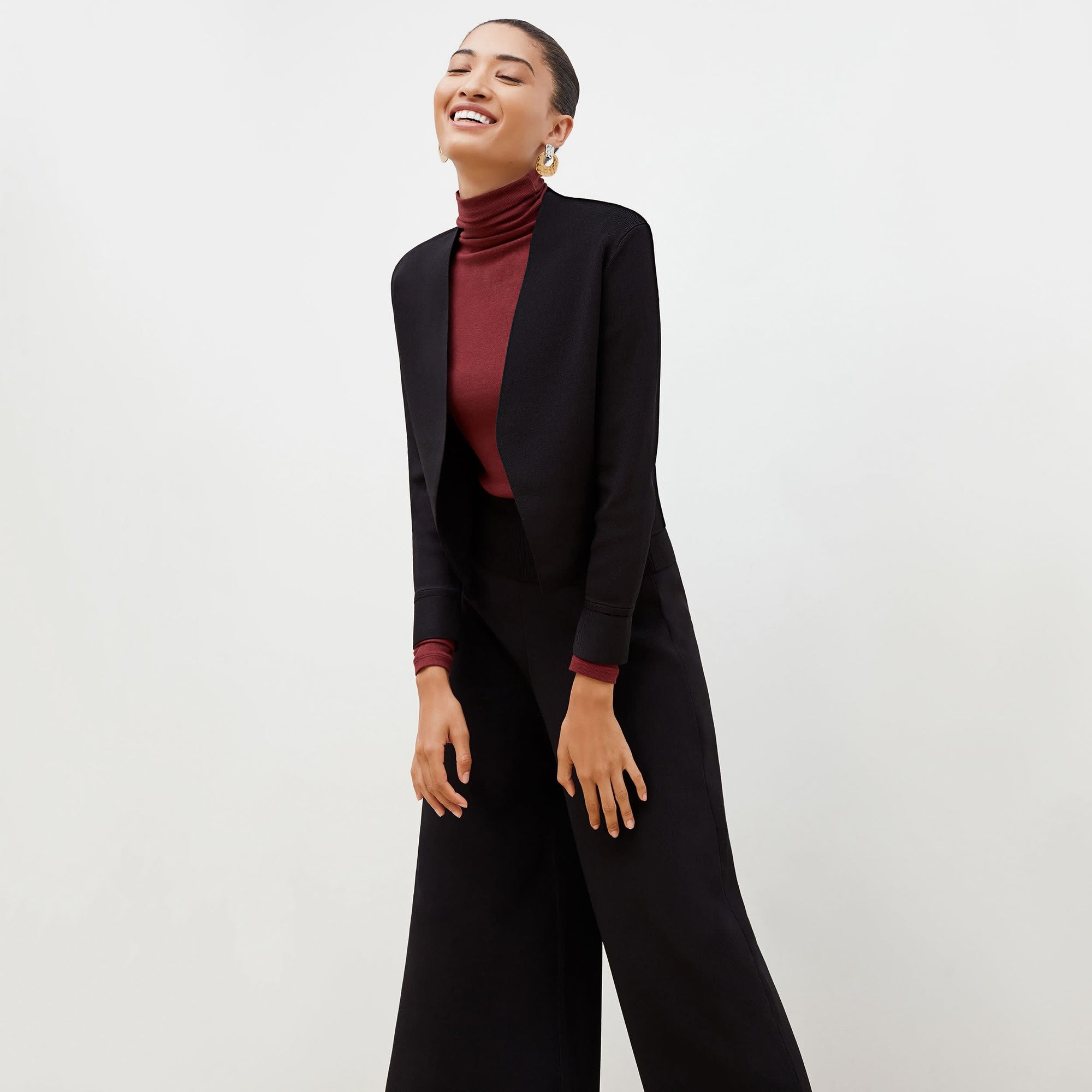 Side image of a woman standing wearing the Sant Ambroeus jardigan in black